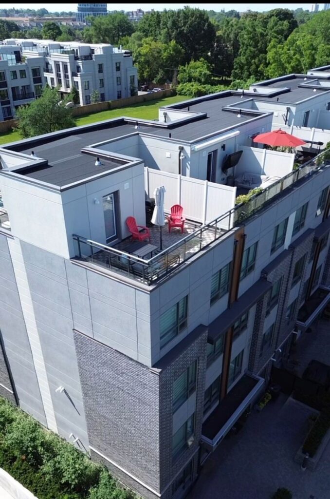 Aerial view of a modern multi-story residential building with aluminum and glass balcony railings, meeting Ontario Building Code safety standards.